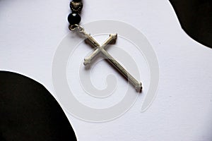 The silver cross on black and white paper background.