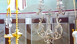 Silver cross with blue stones between two candlesticks, an attribute of the Orthodox Church.