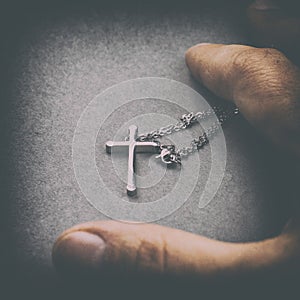 Silver cross in a hand