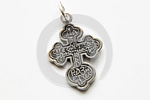 Silver cross on white background close-up