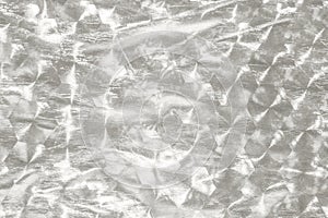 Silver crumpled foil texture background for design and photography