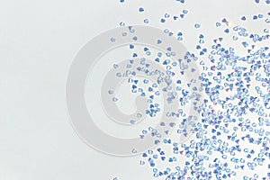 Silver crystal confetti scattered on a blue background.