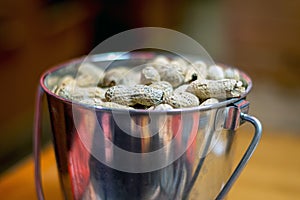 Silver cup of roasted peanuts