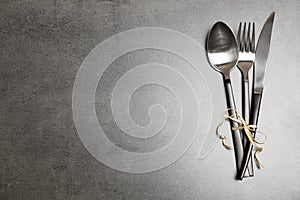 Silver cutlery on gray background, top view