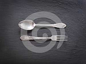 Silver cutlery on a grey background.