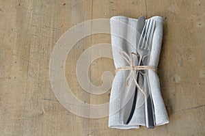 Cutlery with napkin decorated with a notation on a wooden board. Suitable as a background.