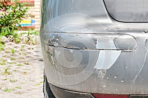 Silver damaged and broken car with dented aluminum metal body scratched and peeling paint from crash accident or collision