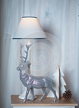 Silver deer and lamp on the bedside table on a white background