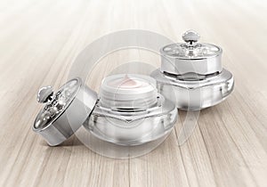 Silver deluxe cosmetic jar on wood