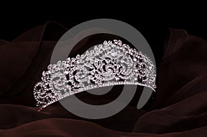 Silver diadem with diamonds isolated on the fabric