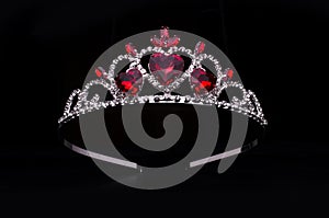Silver diadem with hearts, rubies and diamonds isolated on black