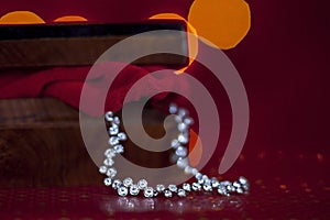 Silver diamond chain in a beautiful wooden casket with red background