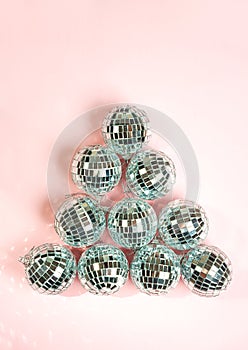 Silver disco balls for decoration party on pastel pink gradient background. Winter New Years Eve party holiday concept. top view,