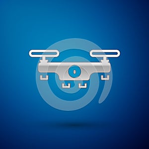 Silver Drone flying icon isolated on blue background. Quadrocopter with video and photo camera symbol. Vector