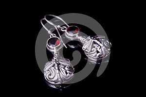 Silver earrings on a black background