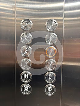 A silver elevator with a red circle on the number 4