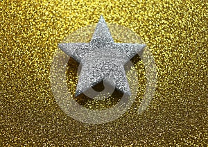 Silver five-pointed star in the glittering golden background