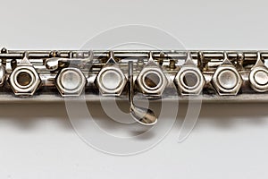 Silver flute with keys on a white sheet