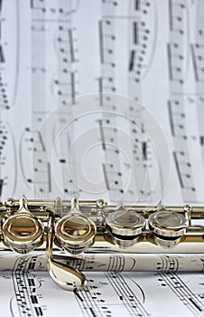 A silver flute on sheet music
