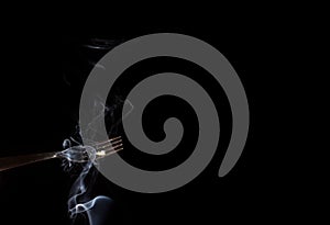 Silver fork with a smoke against a black background