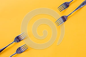 Silver Forks on bright yellow background, creative layout,Kitchen texture, top view Flat lay.Food concept.mock up