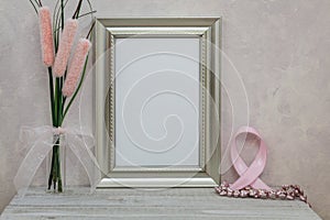 Silver Frame Mockup with pink cancer ribbon against pink textured wall for copy space or artwork