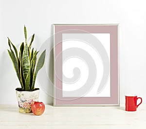 Silver frame mockup with plant pot, mug and apple on wooden shelf