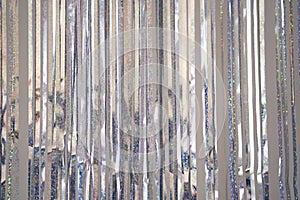 Silver fringe curtains party decoration with copy space. Metallic tinsel rain background. Concept of Christmas, party