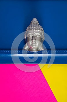 Silver Gautama Buddha Head on Colorful Blue, Pink and Yellow Background
