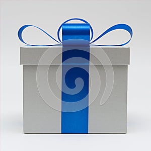 Silver gift box with blue satin bow ribbon on white background