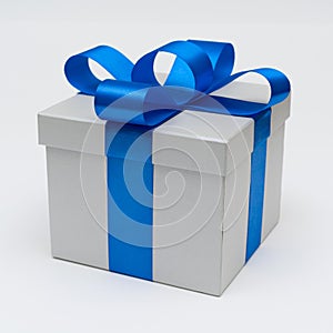 Silver gift box with blue satin bow ribbon on white background