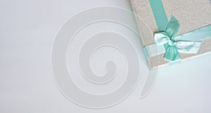 Silver gift box with bright blue bow, flat lay, copy space