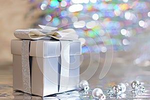 Silver gift box with christmas balls on shiny background