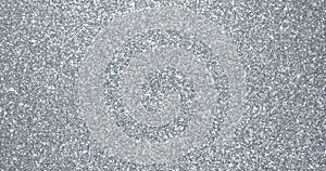 Silver glitter background, sparkling shimmer glow particles texture. Silver light sparks and glittering foil sequins background