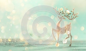 Silver glitter Christmas deer on blue background with lights bokeh, copy space. Greeting card for new year party. Festive holiday