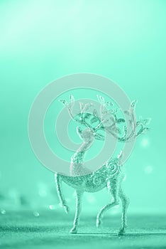 Silver glitter Christmas deer on neon blue background with lights bokeh, copy space. Greeting card for new year party. Festive