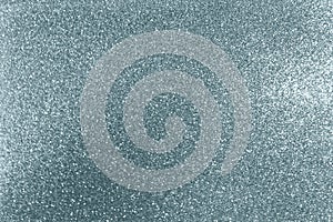 Silver glitter texture background with blur light effect and shiny sparkling particles. Glittering silver or shining snow light fo