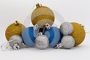Silver, gold and blue shiny Christmas balls on white background