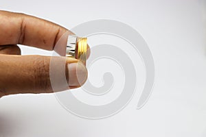 Silver and gold ring in a new condition held in the hand on a white background