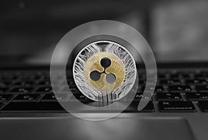 Silver gold ripple coin on a laptop keyboard closeup. Blockchain mining. Digital money and virtual cryptocurrency