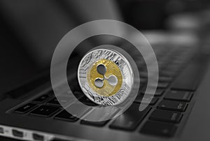 Silver gold ripple coin on a laptop keyboard closeup. Blockchain mining. Digital money and virtual cryptocurrency