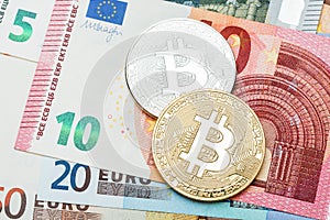 Silver and golden Bitcoin close-up. Euro currency as a backgroun