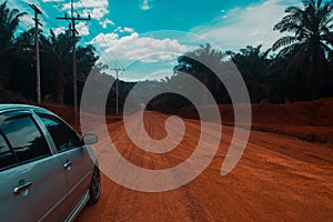 gray color car on the red soild road ,Thailand countrysid nice view