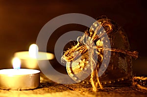 Silver heart on a wooden table with decorations. Valentines day. Love. Gift. Ilustration on a natural background. Candles and fire