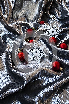 Silver holiday glittering background with place festive inscription and red and white decorations for Christmas tree