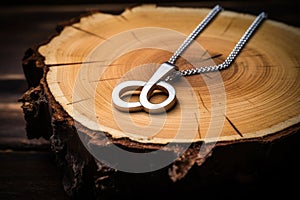 silver infinity symbol pendant on a wooden table