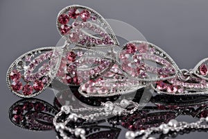 Silver jewelry on the background of a jewellery with pink stones