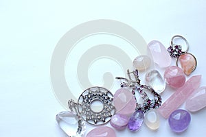 Silver jewelry with natural stones and rose quartz and amethyst stones on a white background. Copy space photo