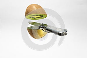 Silver knife cutting floating kiwi. Creative fruit concept