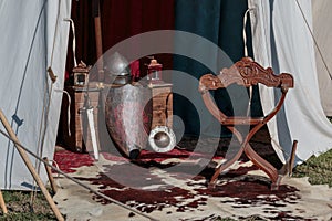 Silver Knight Helmet, Shield and Armour near Wooden Chair in White Tent